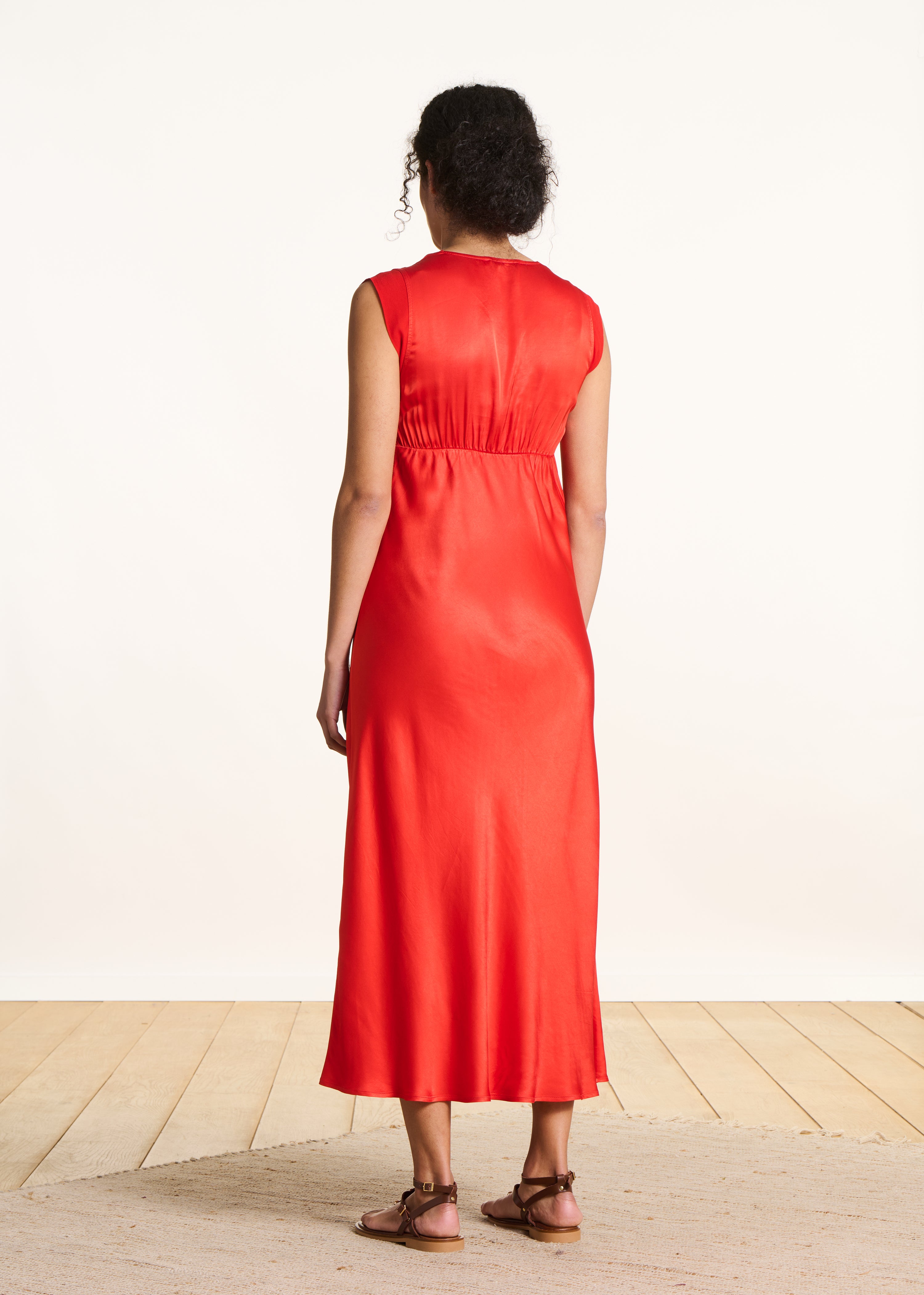 Flowing long orange satin sleeveless dress