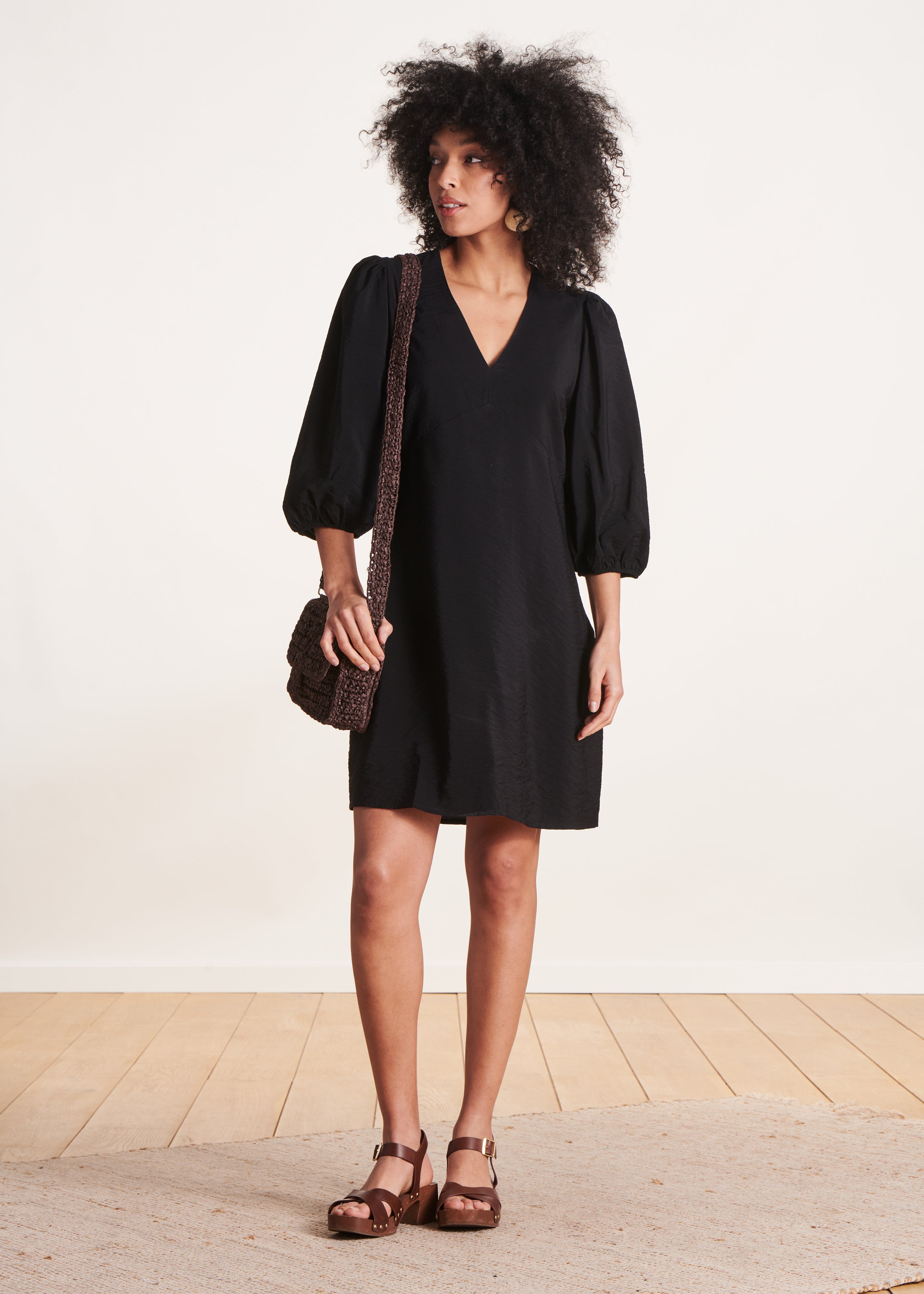 Schwarzes tailliertes kurzes Kleid mit langen Ärmeln