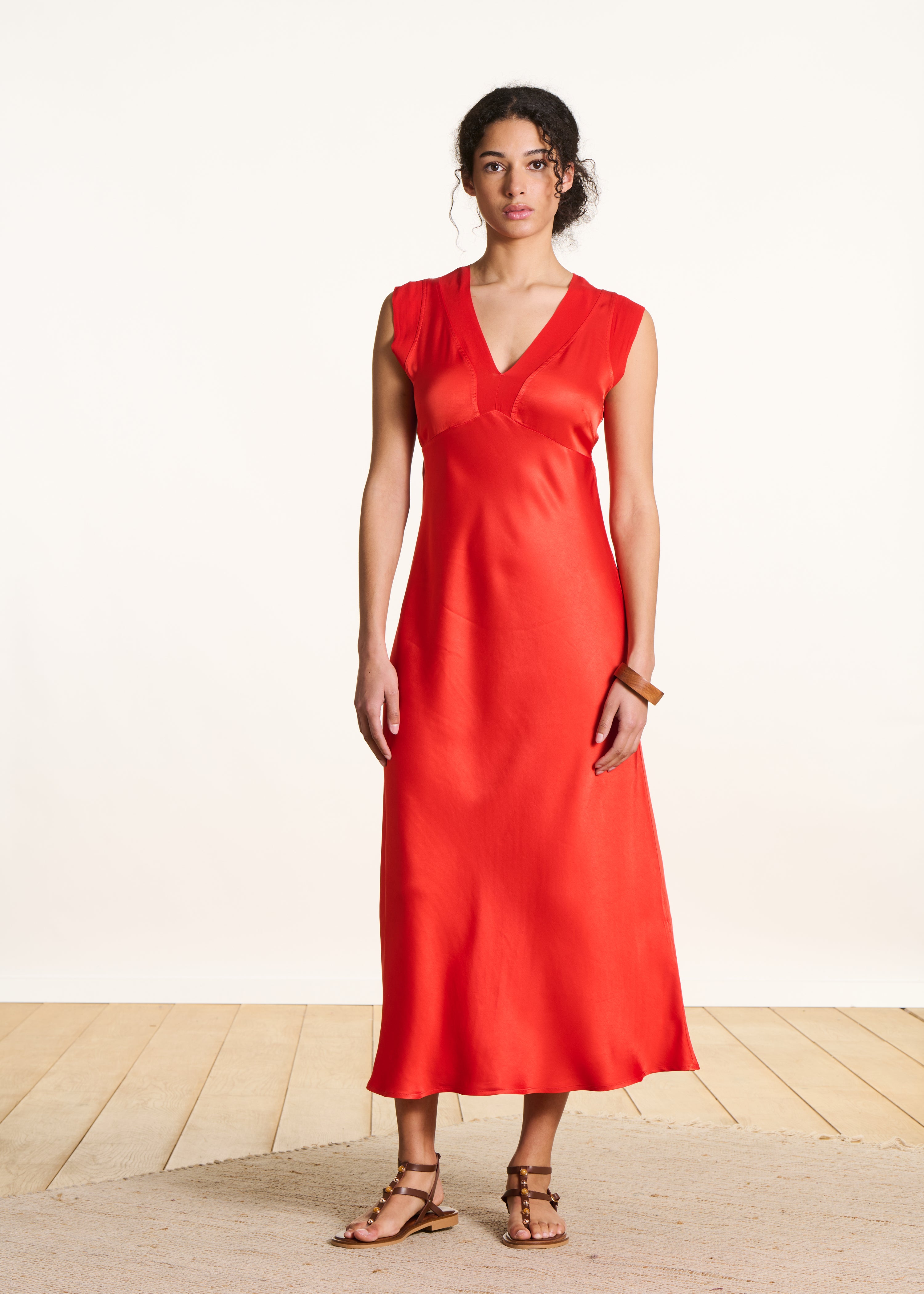 Flowing long orange satin sleeveless dress
