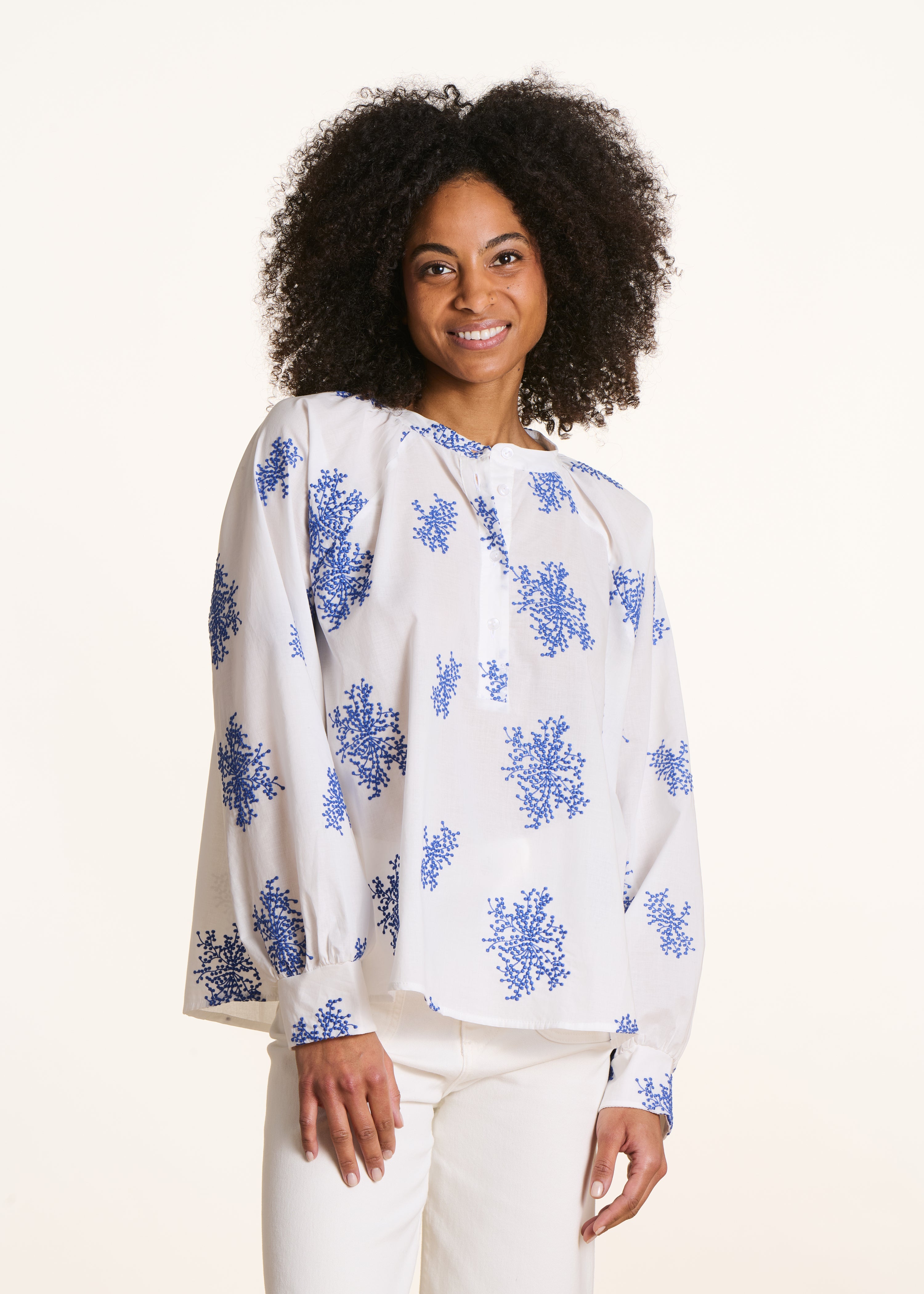 Blusa oversize blanca con bordados azules y mangas largas
