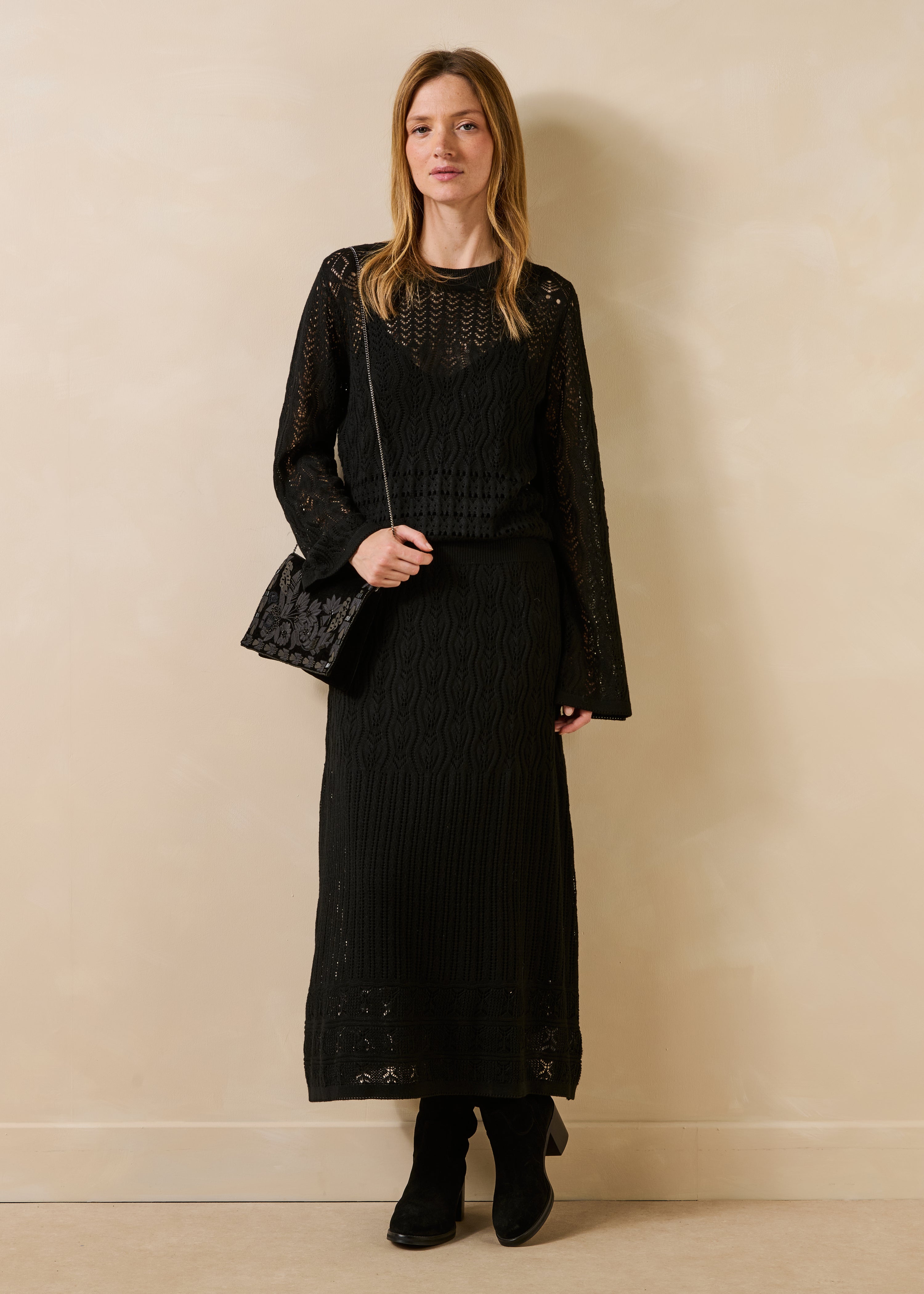Schwarzes, figurbetontes Kleid aus durchbrochenem Strick mit langen Ärmeln
